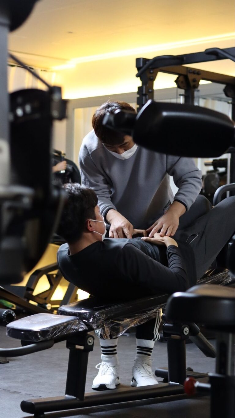 운동 지도 현장에서 자세를 살펴보는 트레이너